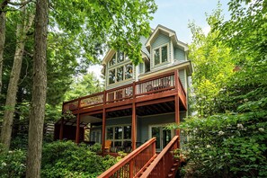 A two-story house with a wooden deck and a covered porch. - Loch Haven by Taylor Made Deep Creek (McHenry)