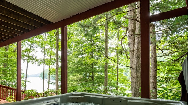 A hot tub with a view of a forest and a lake. - Loch Haven by Taylor Made Deep Creek (McHenry)