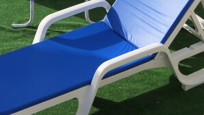 A pool area with a blue inflatable float, a ladder, and a white lounge chair. - Refúgio de Selores (Oliveira de Azeméis)
