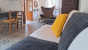 Una stanza con un letto, una sedia, una scrivania e una televisione.