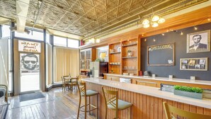 Eine Bar mit Holzbarhocker, einer Theke und Regalen mit verschiedenen Gegenständen.