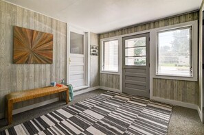 A hallway with a wooden bench, a patterned rug, and a sign that reads "RELAX AND LUMIND."