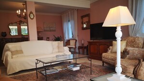 Ein Wohnzimmer mit Sofa, Sessel, Couchtisch und Lampe.