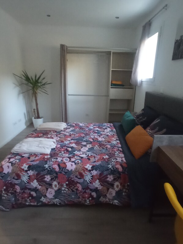 A bedroom with a bed, a desk, a chair, a potted plant, and a wardrobe. - Maison Spacieuse Dans Quartier Calme ET Agreable (Salon-de-Provence)
