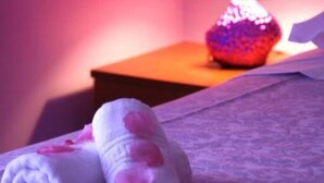 A neatly made bed with rolled towels and a decorative lamp on a wooden nightstand. - B&B A Casa di Giordy (Castro)