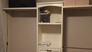 A compact storage unit with shelves, a small drawer, and a hanging rack.