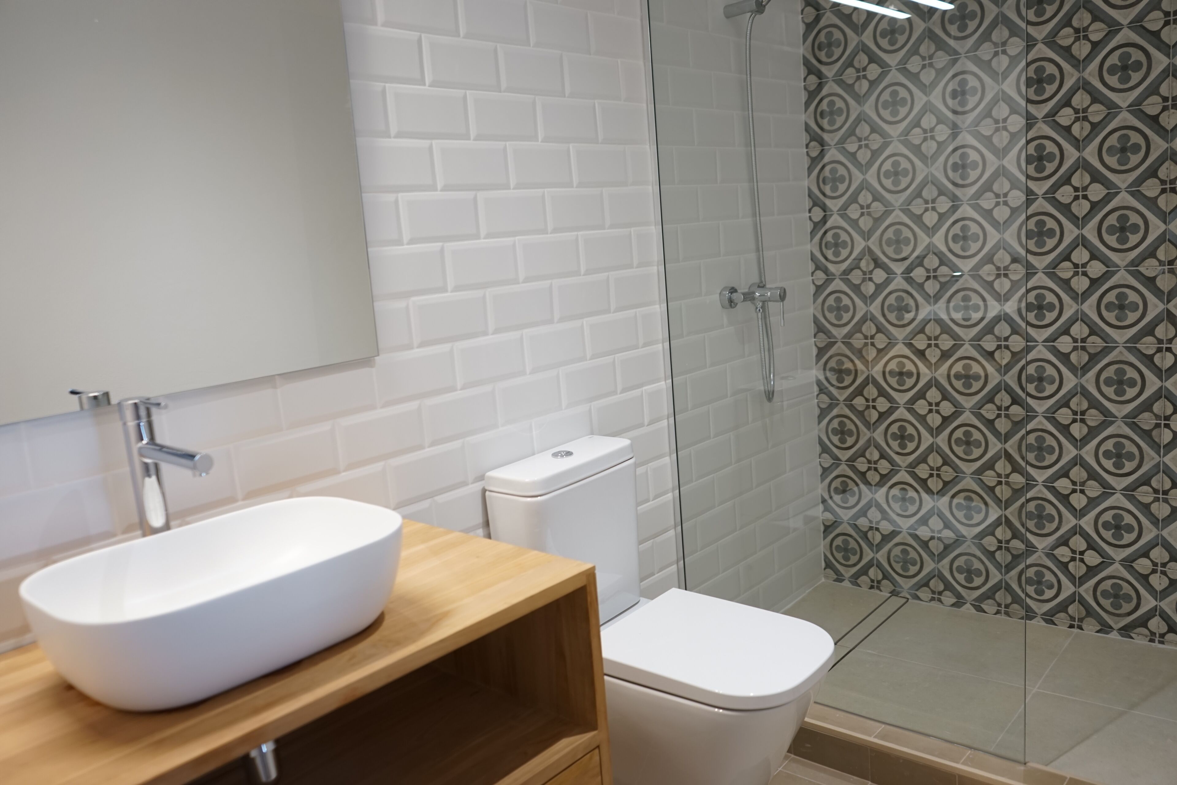 Un baño con lavamanos, inodoro y ducha blancos.