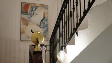 Un escalier avec une rampe noire et un luminaire.