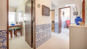Un pasillo con comedor, cocina y sala de estar.