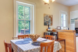 Enjoy meals in this cozy dining area with a table set for two, featuring a beautiful view of the surrounding greenery.