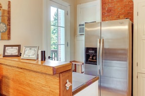 Kitchen area with a refrigerator, countertop, and window offering a view.