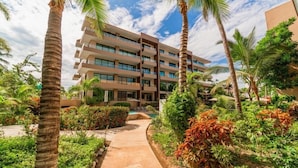 A multi-story hotel with balconies, surrounded by lush greenery and palm trees. - Villa Dahlia Estudio a metros del mar (San Francisco)