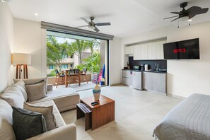 A modern living room with a sofa, coffee table, and a TV mounted on the wall. - Villa Dahlia Estudio a metros del mar (San Francisco)
