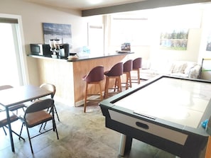 Relax and socialize in this spacious room featuring a pool table, bar counter, and seating area.