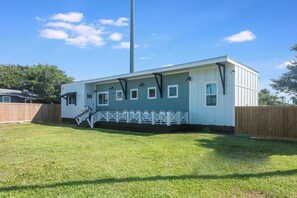 A single-story house with a front porch and a small staircase leading to the entrance. - Chillin at the Beach by Silver Sands Vacation Rentals (Port Aransas)