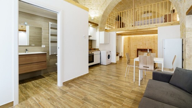 Ein modernes Interieur mit einer Küche, einem Essbereich und einem Wohnzimmer mit einer Steingewölbedecke.