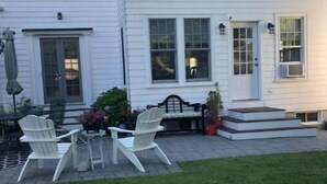 A white two-story house with a patio area featuring outdoor furniture and a small garden. - House in Newport (Newport)