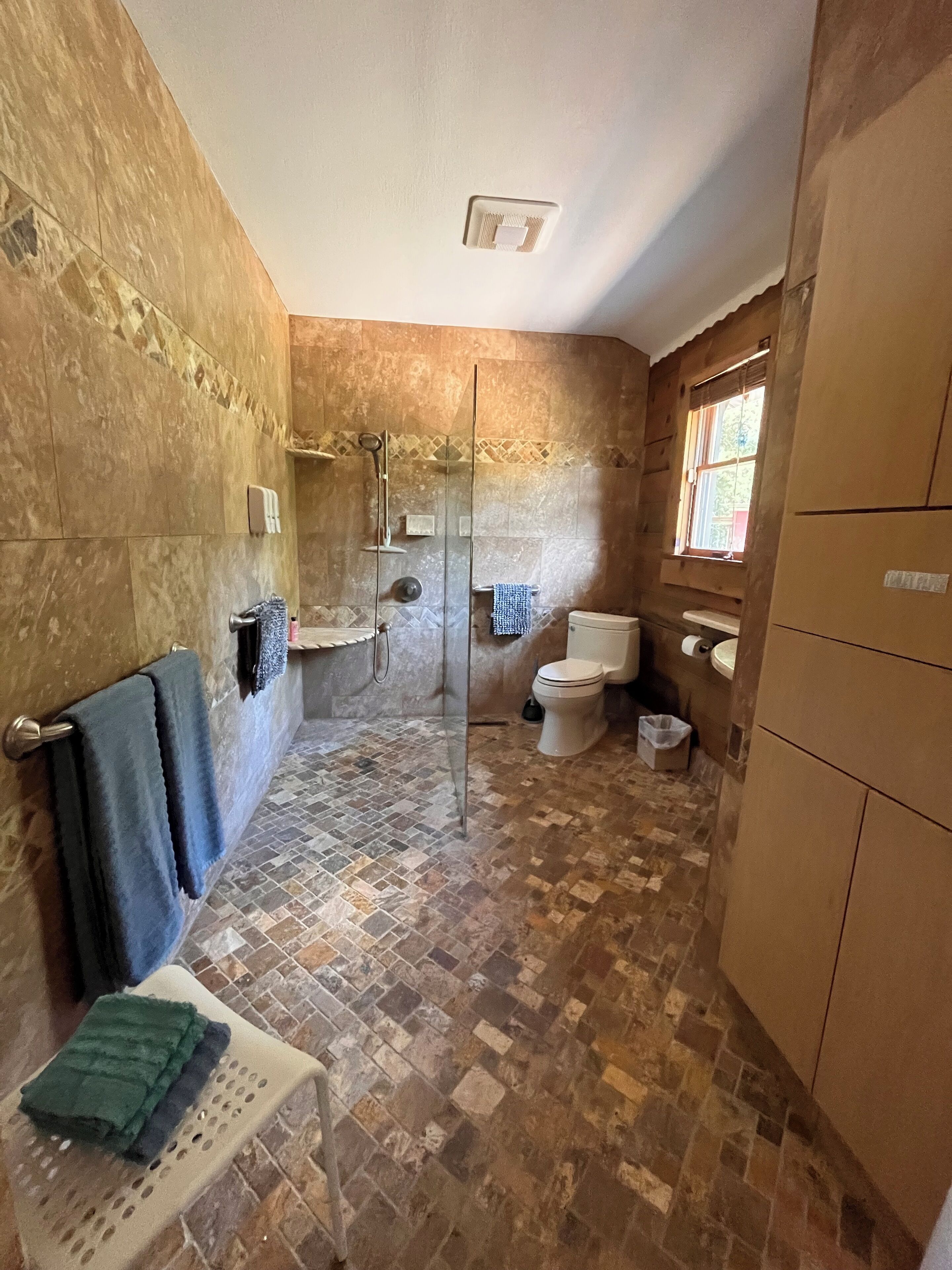 Et badeværelse med brusebad, toilet og vask.