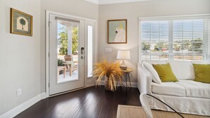 A living room with a white sofa, a lamp, and a door leading to a patio. - 2-bedroom vacation home just a short walk to Rosemary Beach (Rosemary Beach)