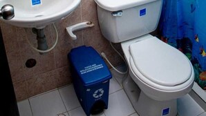 A bathroom with a sink, toilet, and shower curtain. - Hotel Ruta Del Mar (Santa Marta)