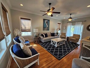 A spacious living room with a large sofa, two armchairs, a coffee table, and a ceiling fan. - Pelican Point Villa, Edisto Beach, Plantation Golf Course (Edisto Island)