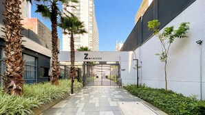 A pathway leading to a building with a sign reading "Zinelholos." - New studio in Pinheiros - Great Location - comfort - safety (Pinheiros São Paulo)
