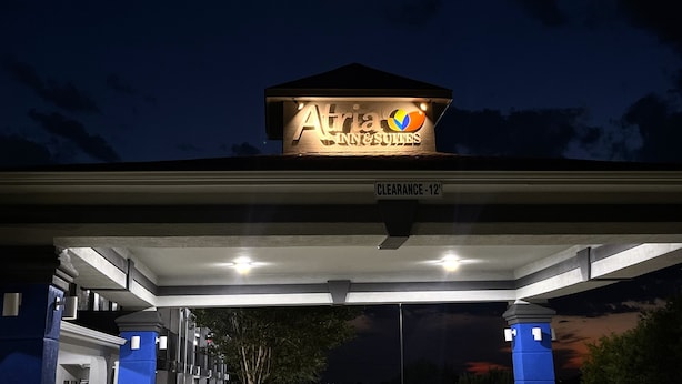 Eine Tankstelle mit einem Schild für 'Atria Inn & Suites' und einem Schild mit der Aufschrift 'Reduziert - 12'.
