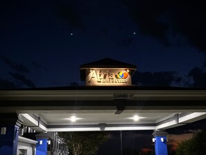 A gas station with a sign for 'Atria Inn & Suites' and a 'Clearance - 12' sign. - Atria Inn & Suites (San Antonio)
