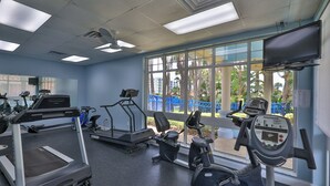 Een fitnessruimte met loopbanden, elliptische trainers en hometrainers.