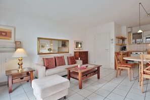 Un salon moderne comprenant un canapé, une table basse et un coin repas avec une table et des chaises.