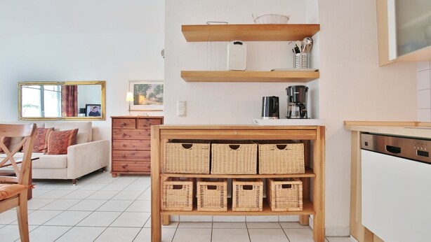 Eine moderne Küche mit Holzböden, Korbwäschekörben und einer Kaffeemaschine.