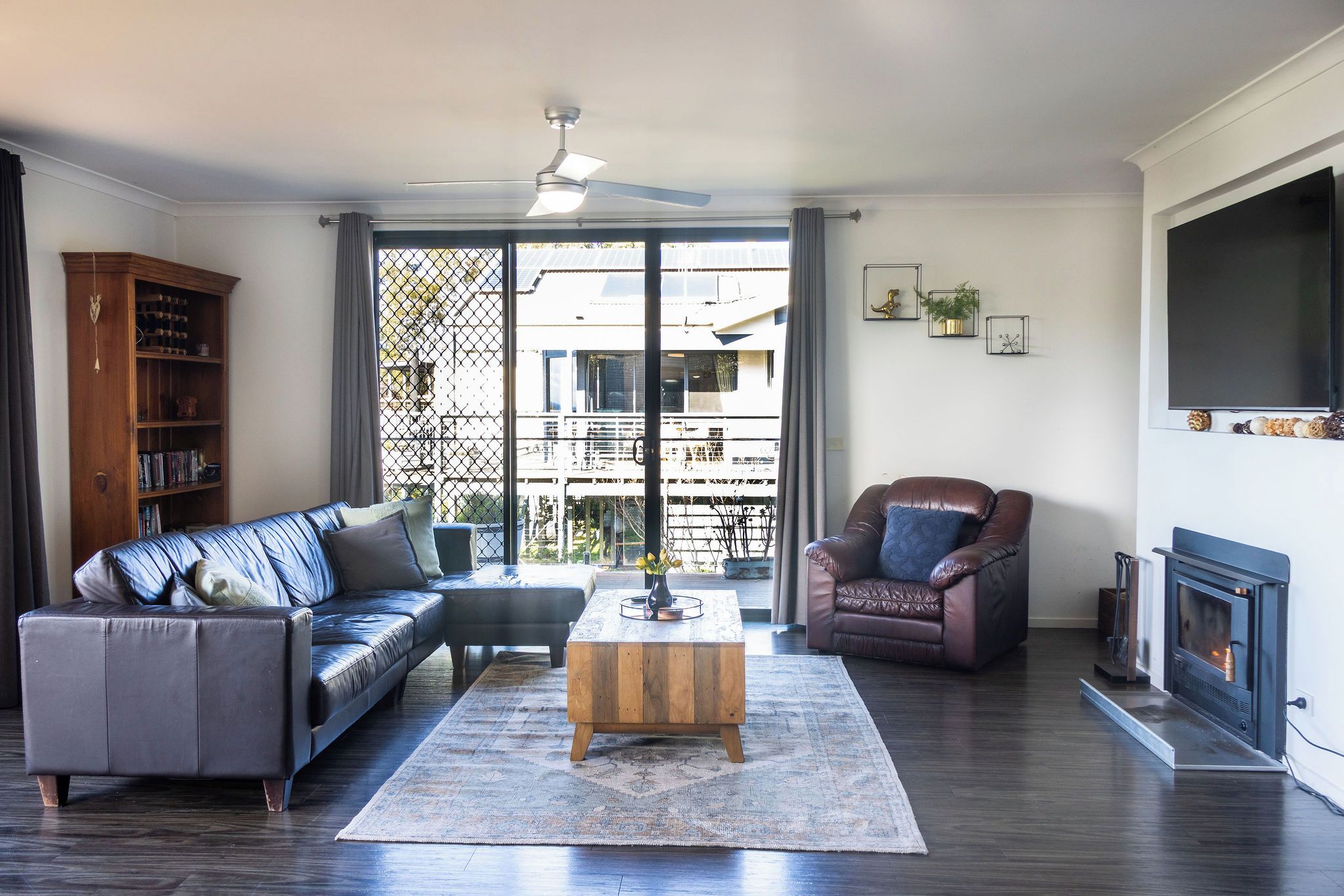 A living room with a sofa, armchair, coffee table, and a fireplace.