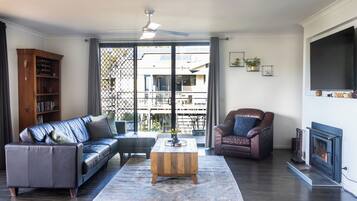 A living room with a sofa, armchair, coffee table, and a fireplace.