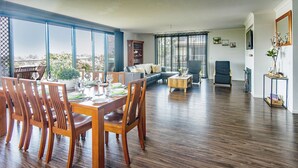 A spacious living area with a dining table set for six, a sofa, and a coffee table. - Bella Views Pet friendly with expansive views. (Mallacoota)
