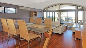 Enjoy meals in this dining area with a glass-top table and six chairs, surrounded by a large window offering a view of the outdoors.