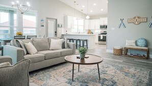 Una sala de estar moderna con un sofá color beige, una mesa de centro y una alfombra estampada.