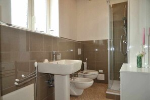 A bathroom with a sink, two toilets, and a shower. - Palazzo Maggiore B Suite B (Noale)