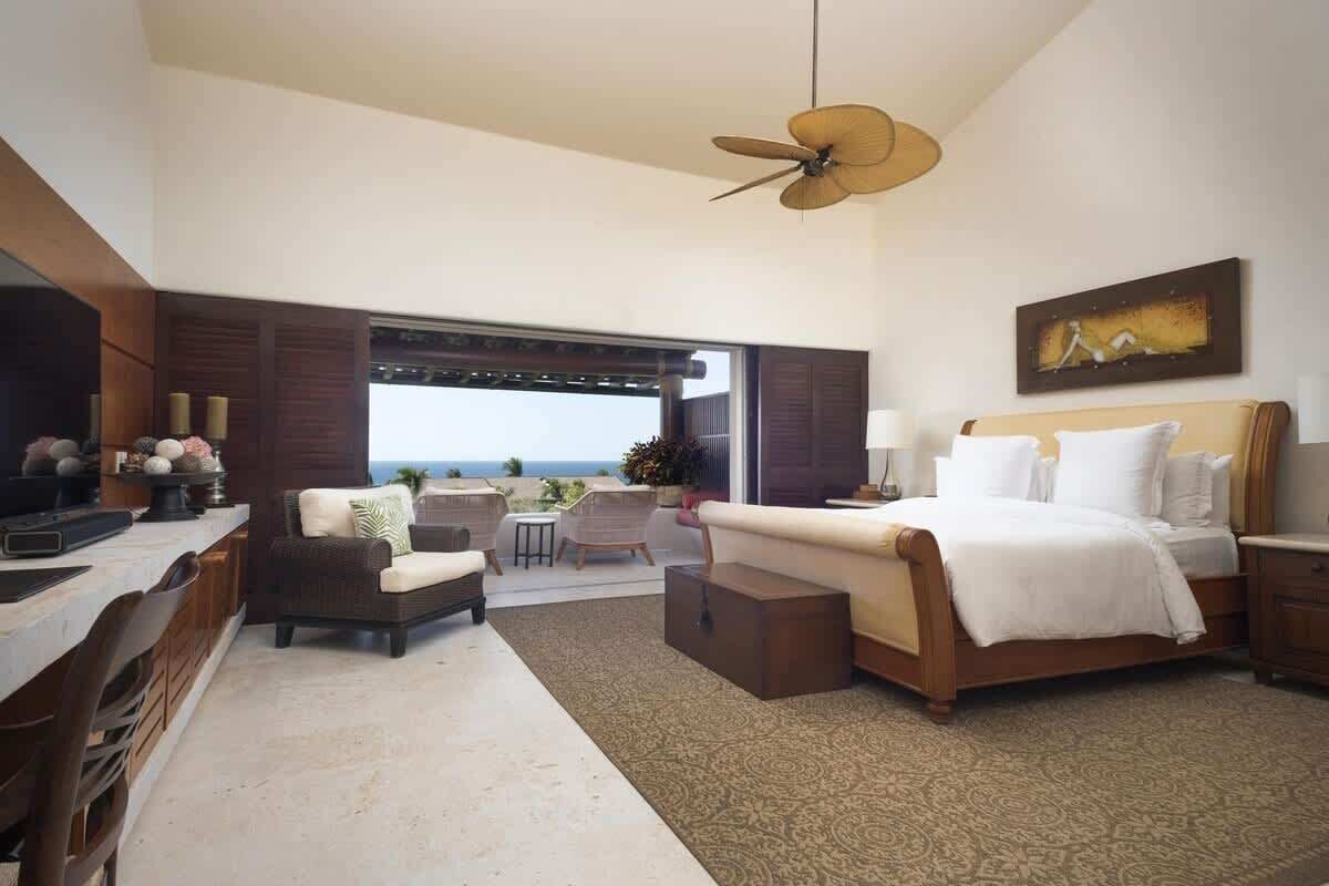 A spacious bedroom with a large bed, a desk, and a seating area.