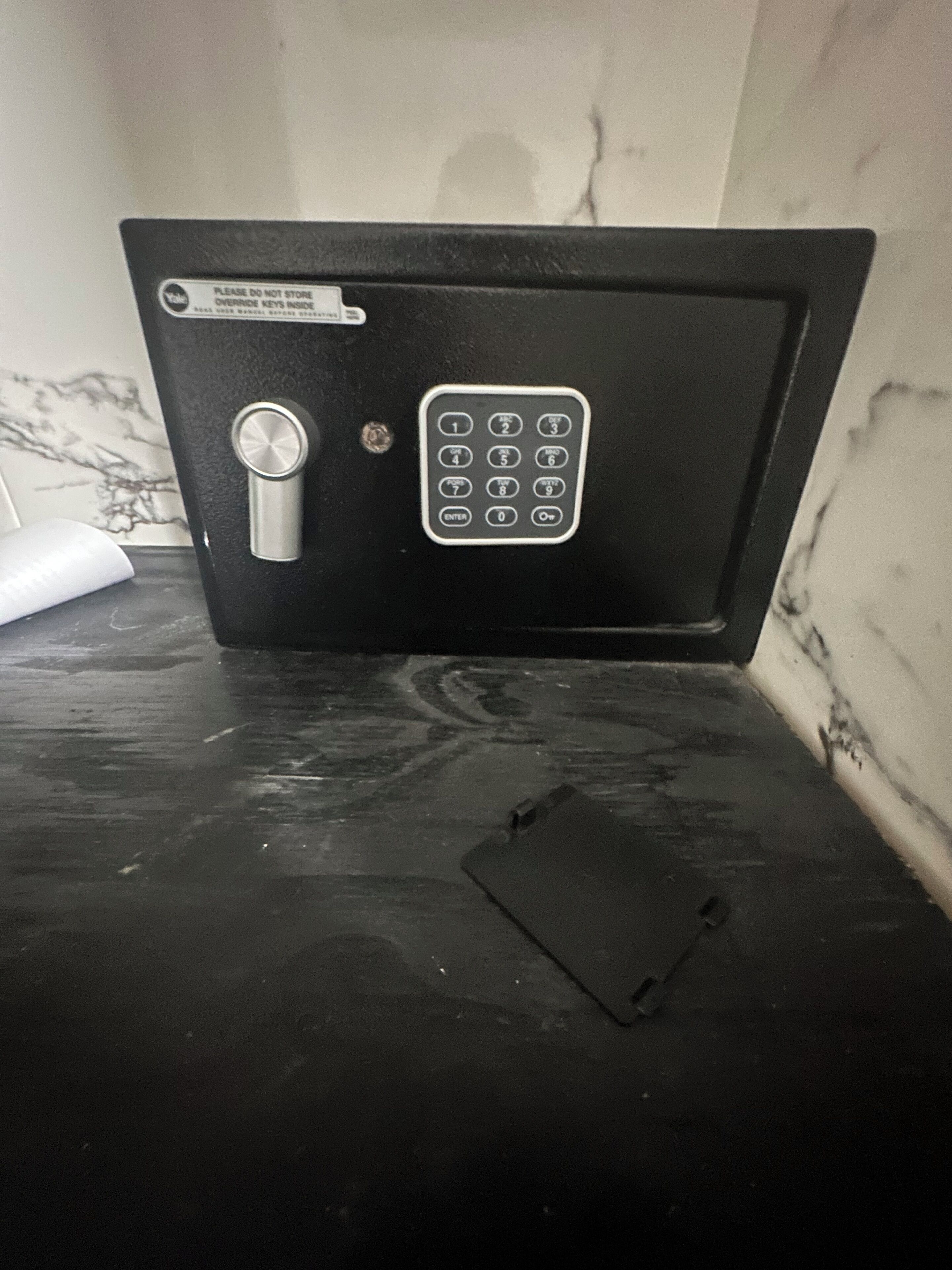 Ein schwarzer Tresor mit Tastatur auf einer Marmorplatte.