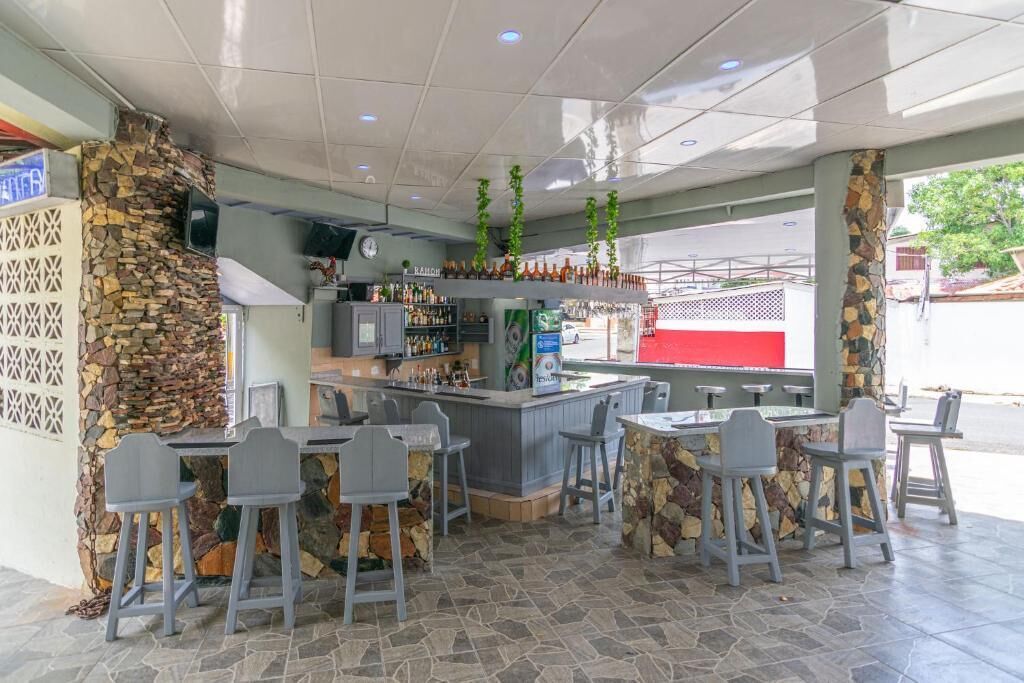 Een restaurant met een stenen muur, een bar en terras.