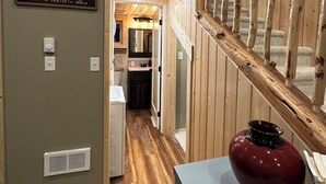 Un intérieur en bois avec une enseigne indiquant « Station d’hibernation » et un escalier menant à un deuxième étage.