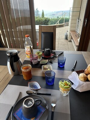 A table set for breakfast with a view of the countryside.