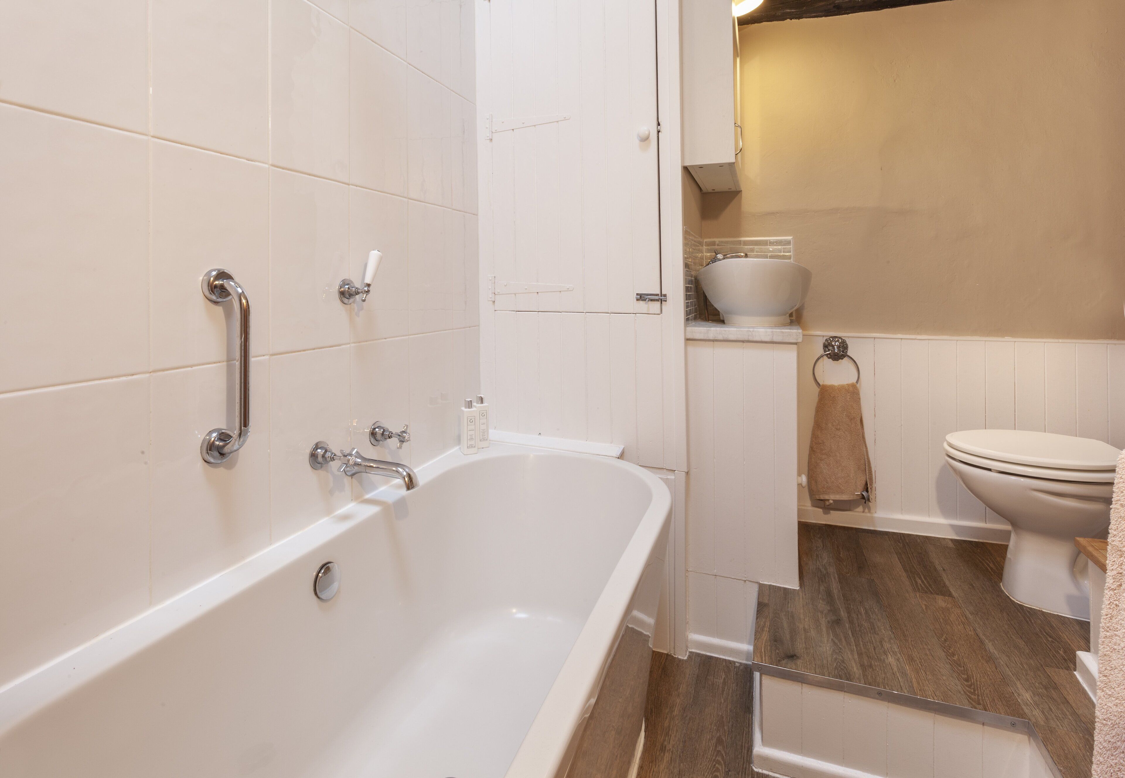 A bathroom with a white bathtub, a toilet, and a sink.