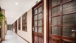 A hallway with wooden doors and frosted glass panels, leading to rooms. - Giao Thong Hotel (Hanoi)