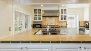 A kitchen with white cabinets, a stainless steel stove, and a microwave.