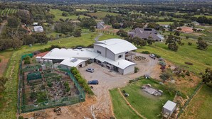 A large, modern house with a curved roof and a spacious garden. - Magnificient Four Bedroom Home, Amazing Views (Baskerville)