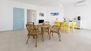 A modern living room with a dining area, featuring wicker chairs, a round table, and a white sofa. - Rosetta Mare in Alcamo Marina (Alcamo)