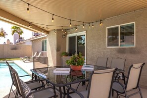 An outdoor patio with a glass table, chairs, and a potted plant. - FoxTrotter | Pool Heat Included | Sleeps 12 (Scottsdale)