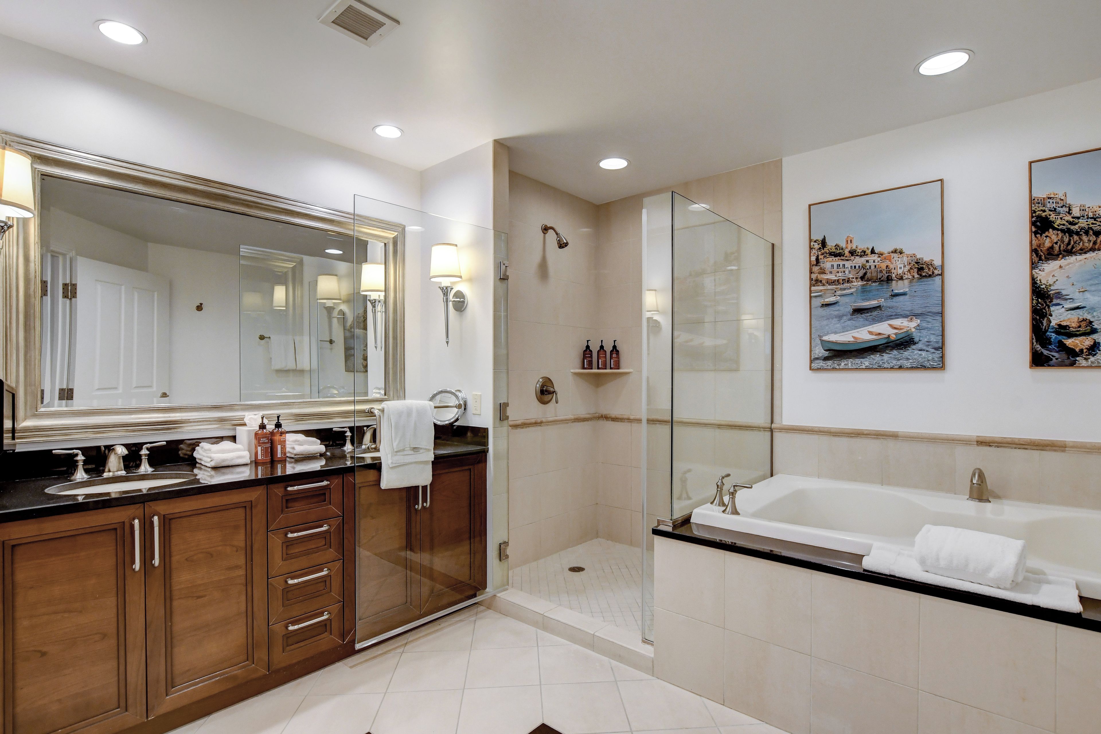 A modern bathroom with a large mirror, a bathtub, and a shower area.