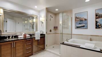 A modern bathroom with a large mirror, a bathtub, and a shower area.